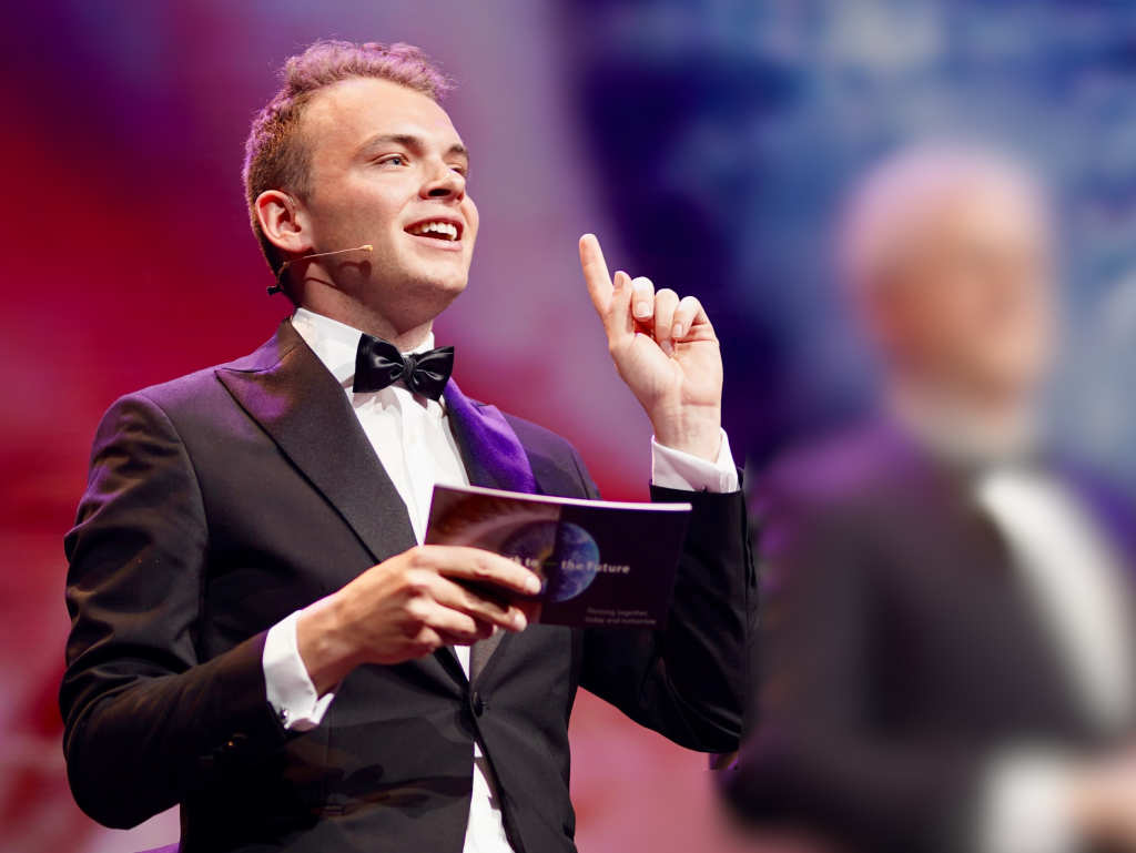 Wout close-up pointing finger at the sky, indicating hosting skills.