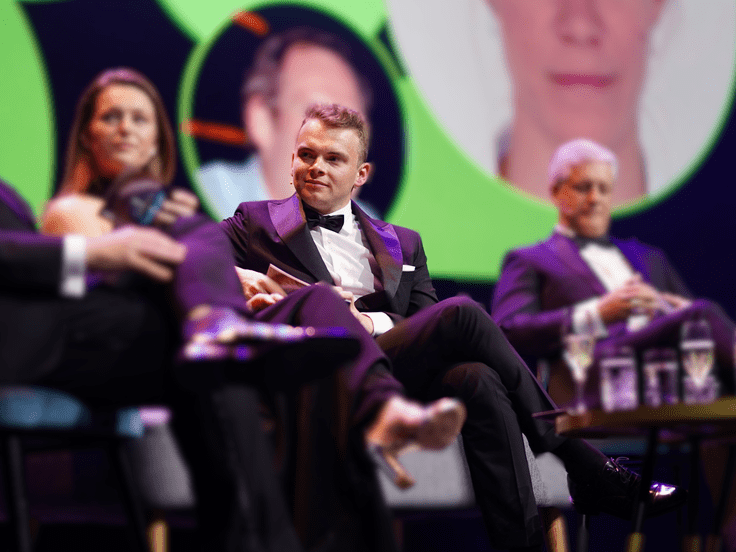 Wout interviewing on sofa with some guests in a TV show environment, live on stage.